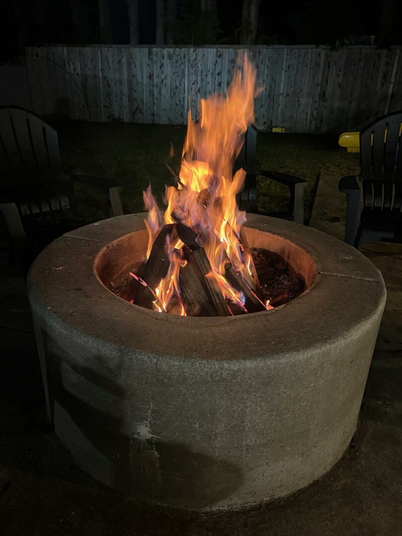 Outdoor concrete fire pit providing warmth and style as part of a custom hardscape project.