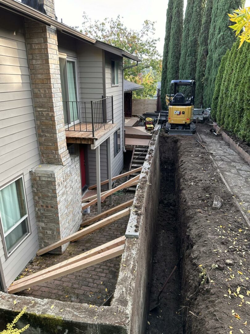 Mini excavator performing tight-access excavation between buildings, showcasing trenching precision.